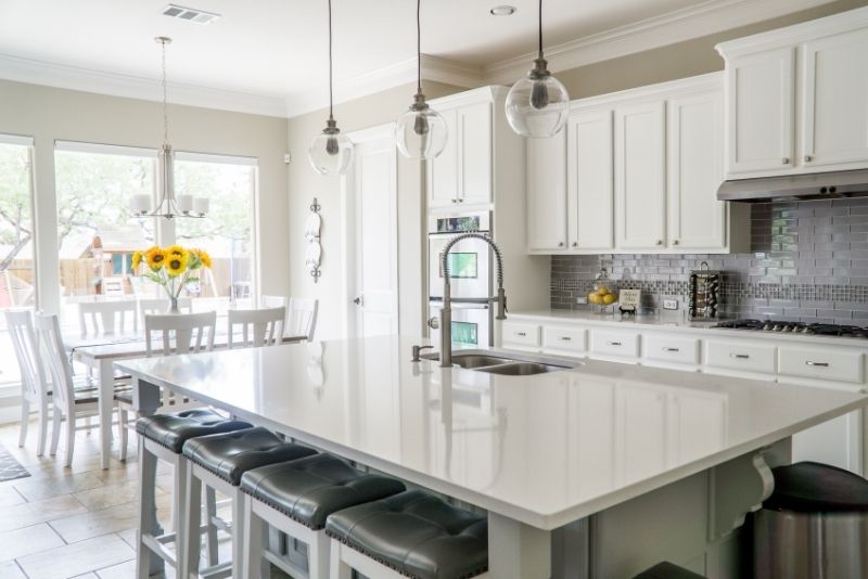 A custom made kitchen with white cabinets and an island