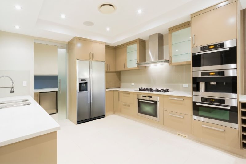 Cream gloss kitchen cabinetry with built-in oven tower and gas cooktop